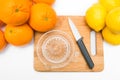 Squeezes fresh oranges with a juicer. Orange juice in a glass close to half of sliced Ã¢â¬â¹Ã¢â¬â¹oranges on a white background. Royalty Free Stock Photo